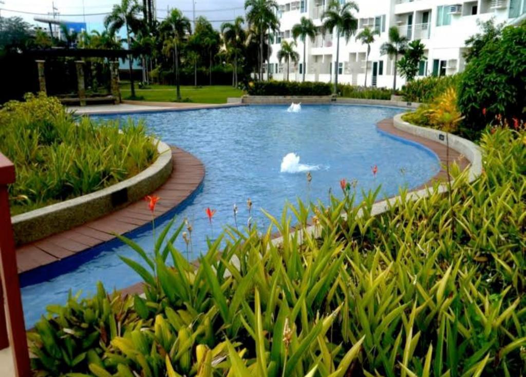 a pool with swans in the water in a resort at Alabang Staycation in Manila