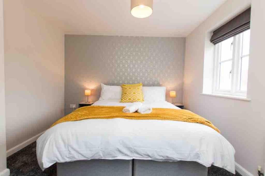 a bedroom with a large bed and a window at CLOUDSTAYS - Luxury 3 Bed Townhouse - Sleeps upto 8 Birmingham City and Central - Free Parking & WIFI in Birmingham