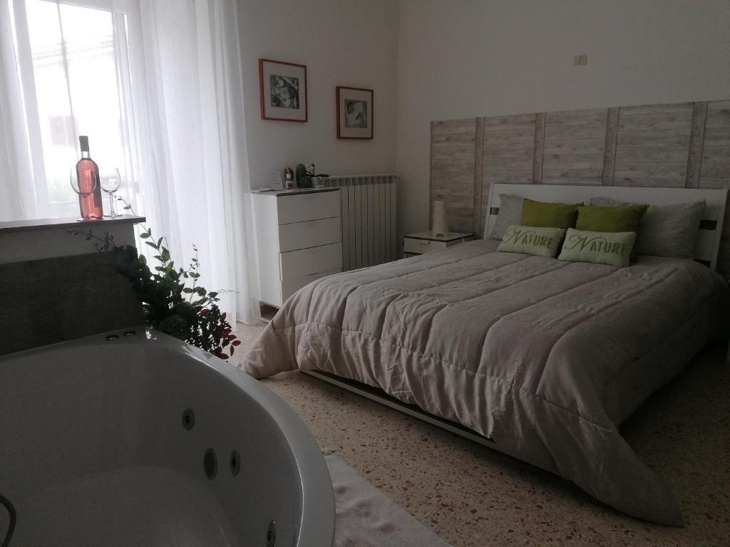 - une chambre avec un grand lit et une baignoire dans l'établissement Casa rosa Abruzzo 3, à Musellaro