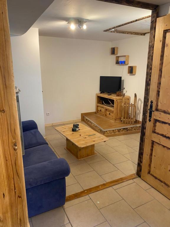 sala de estar con sofá azul y TV en Appartement 4 personnes en Villar-dʼArène