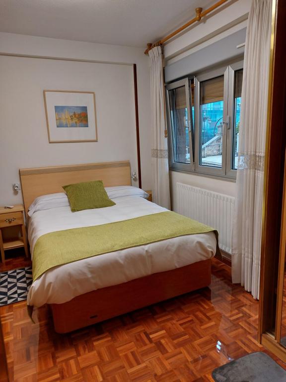 - une chambre dotée d'un lit avec un oreiller vert dans l'établissement El Trébol, à Oviedo