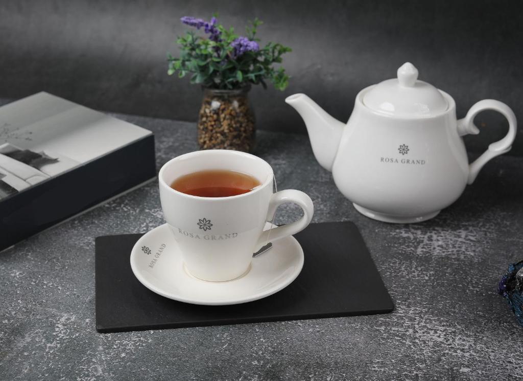 a cup of tea and a teapot on a table at Rosa Grand Hotel in Riyadh