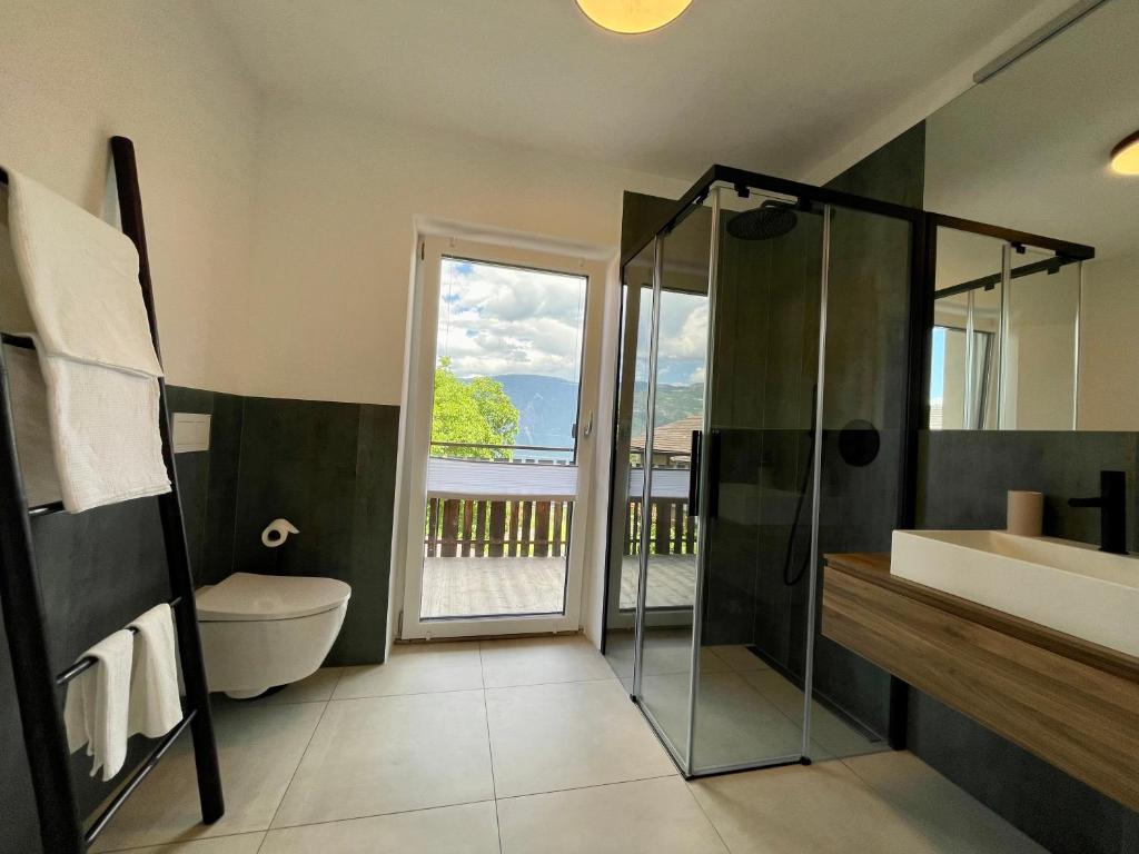 een badkamer met een douche, een wastafel en een toilet bij Mountain View Suites in Tisens
