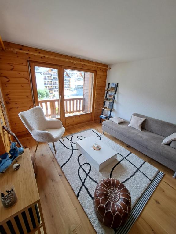 ein Wohnzimmer mit einem Sofa und einem Tisch in der Unterkunft Appartement de charme - Idéal pour un couple in Nendaz