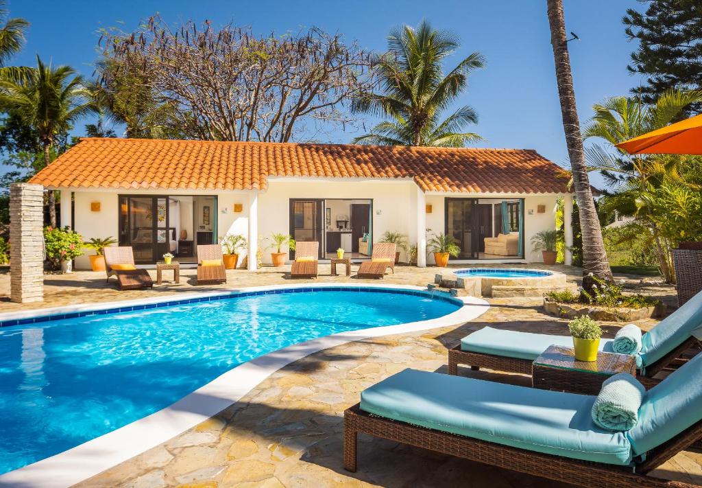 a villa with a swimming pool and a resort at Garden By The Sea in Sosúa