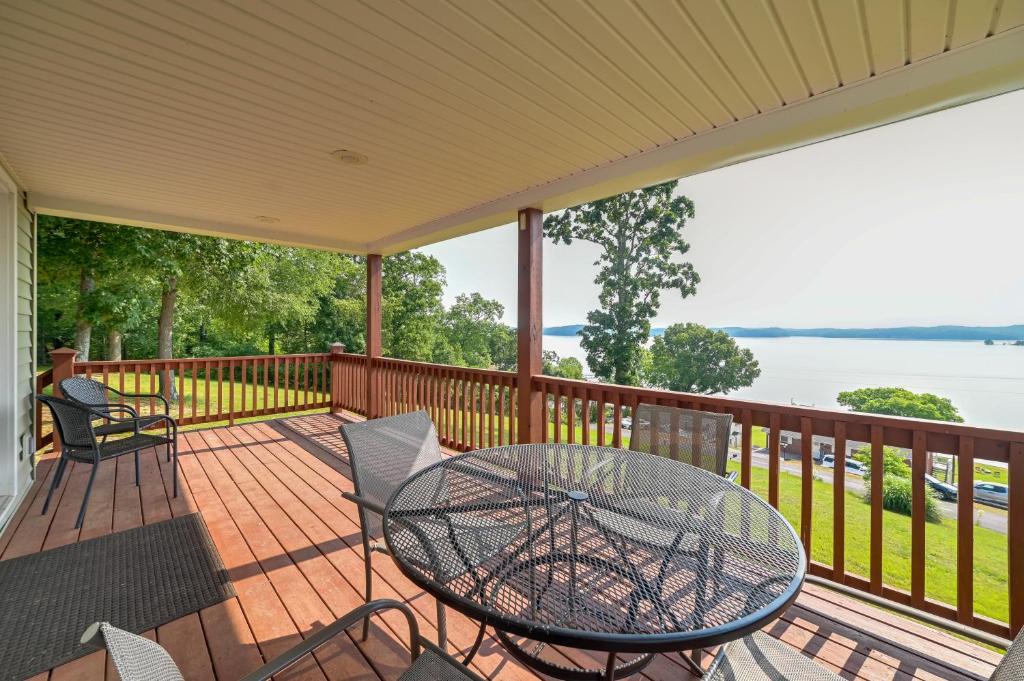 eine Terrasse mit einem Tisch und Stühlen auf einer Terrasse in der Unterkunft Kentucky Lake Getaway with Lookout Deck, Water View! in New Concord