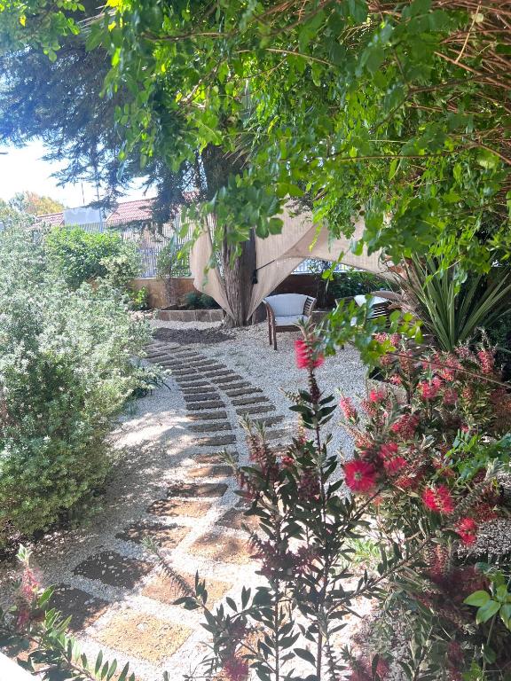 a garden with a bench and some flowers and trees at tulipano rosso in Bari