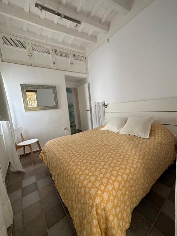 a bedroom with a large bed with a yellow blanket at Apartamento en el casco histórico in Tarifa