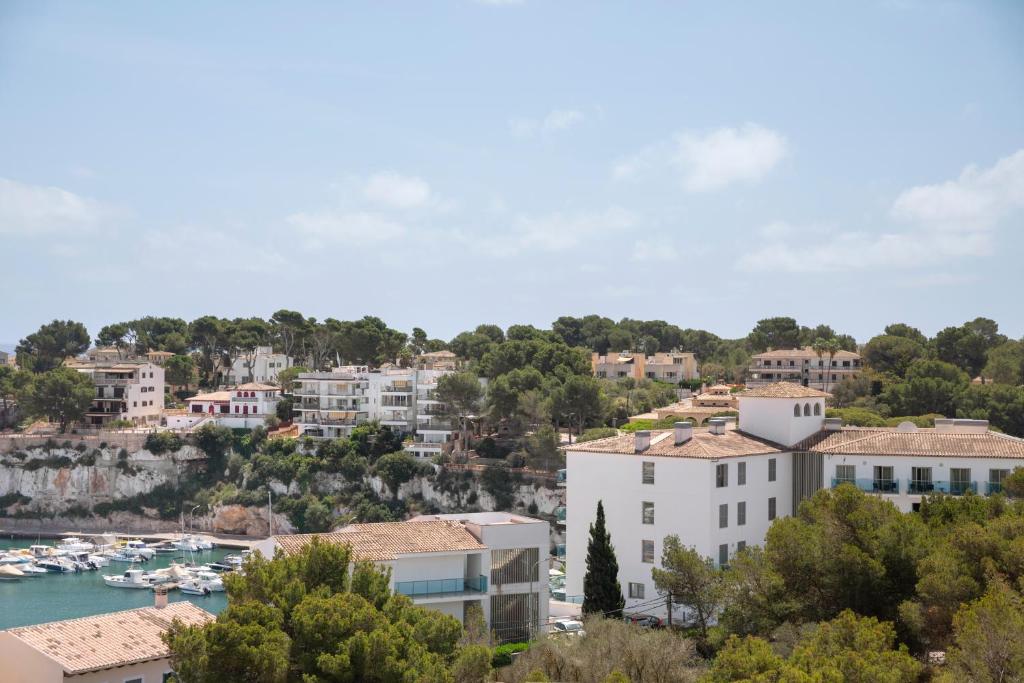 a view of a city with boats in a harbor at Aparthotel Marina Drach in Porto Cristo