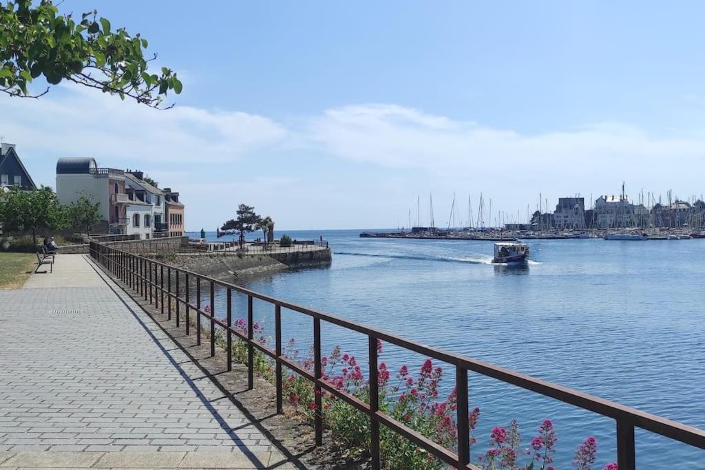 une clôture à côté d'une masse d'eau avec un bateau dans l'établissement Appartement T3 confortable et idéalement situé, à Concarneau