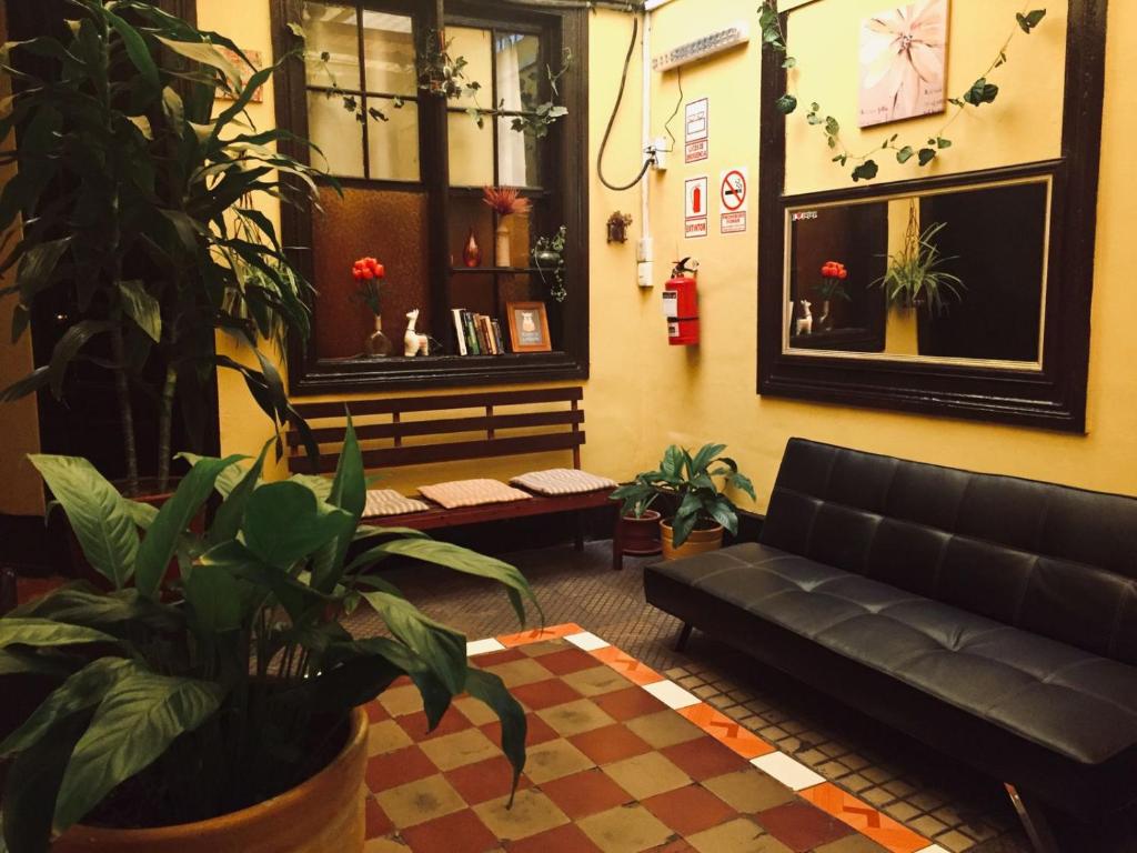 a living room with a black couch and plants at KORICANCHA in Lima