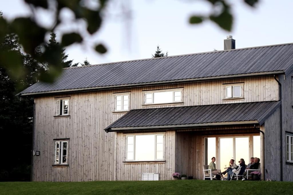 Leute, die vor einer Scheune auf Stühlen sitzen in der Unterkunft Lille Herstrand - A unique seaside getaway in Meløyskagen