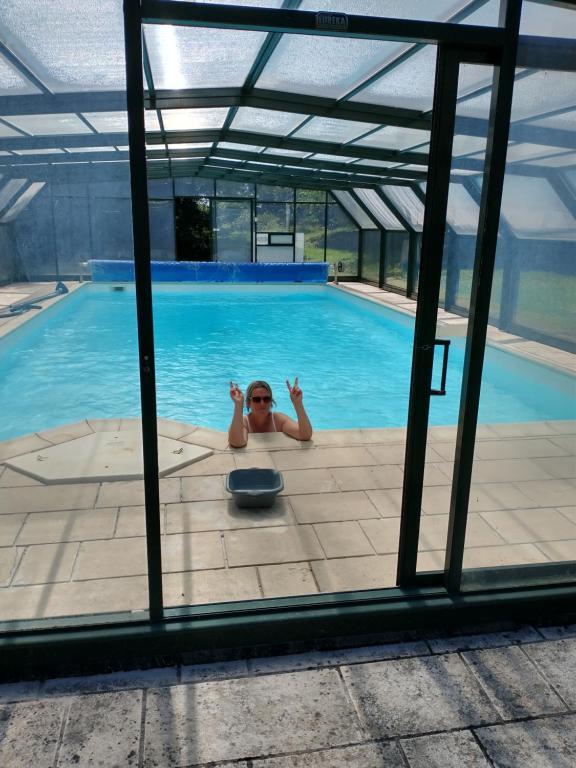 une femme se pose dans une piscine dans l'établissement La fantasia gîte, à Saint-Sylvain-dʼAnjou