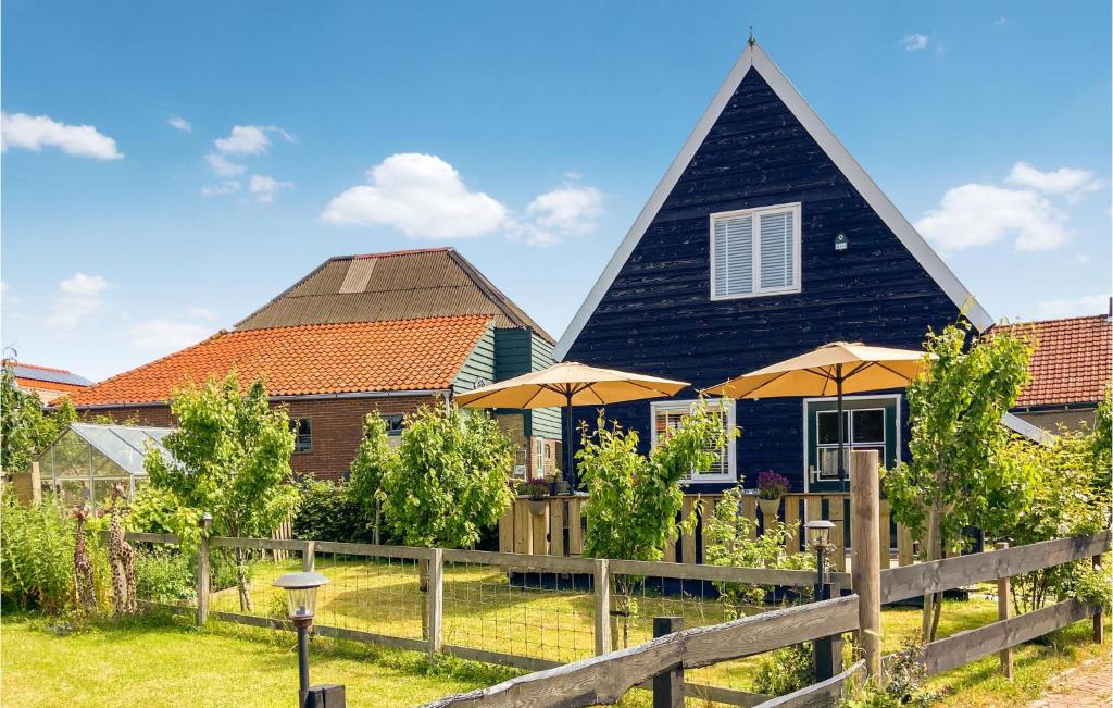 une maison avec un toit noir et des parasols dans l'établissement Lovely Home In Den Oever With Kitchen, à Den Oever
