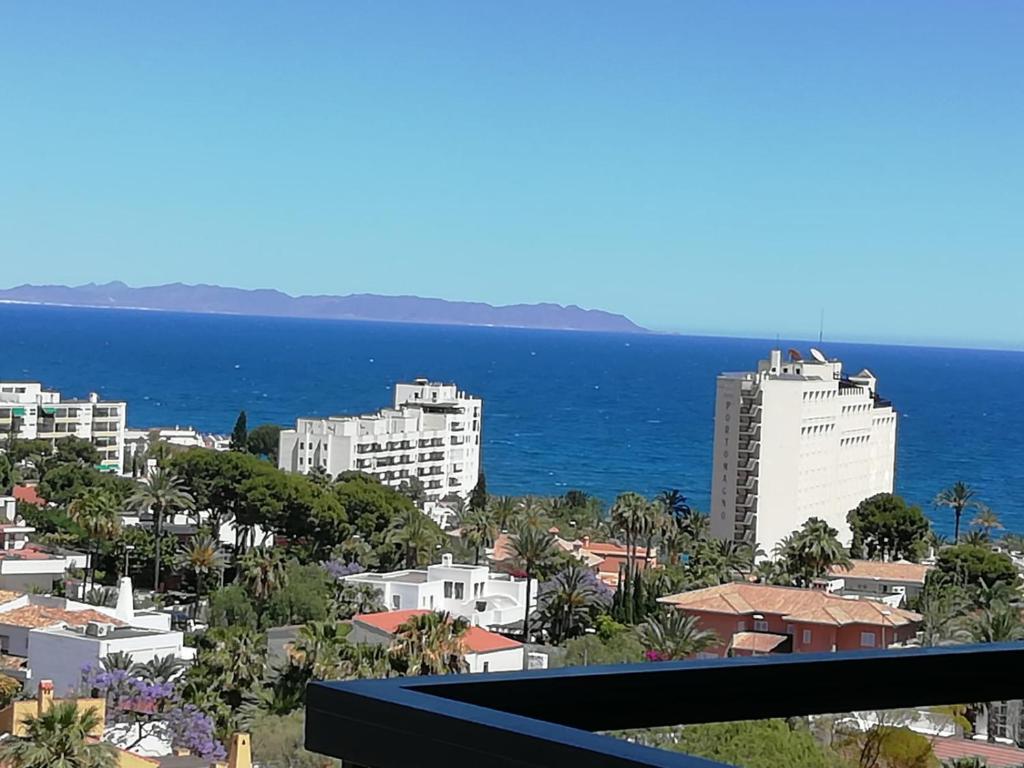 einen Balkon mit Blick auf Gebäude und das Meer in der Unterkunft Aguaserena1 in Almería