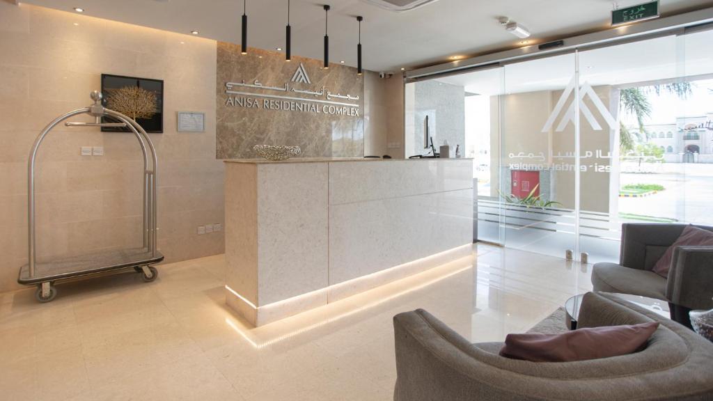 a lobby with a shower and chairs in a building at Anisa Residential Complex in Salalah