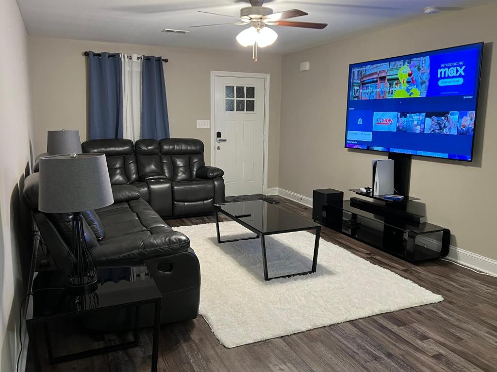 a living room with black leather furniture and a flat screen tv at Spotless in Clarksville