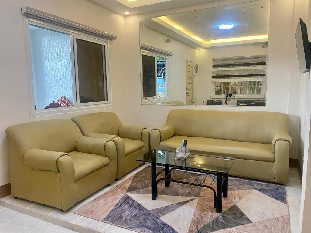 a living room with two couches and a coffee table at Teo’s Spacious and Affordable Home in Cabanatuan in Cabanatuan