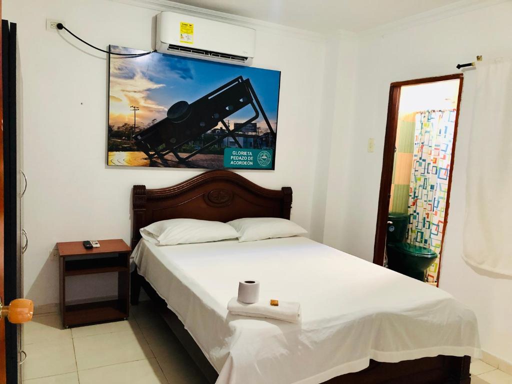 1 dormitorio con 1 cama y una foto en la pared en Hotel Casa Martina Valledupar en Valledupar