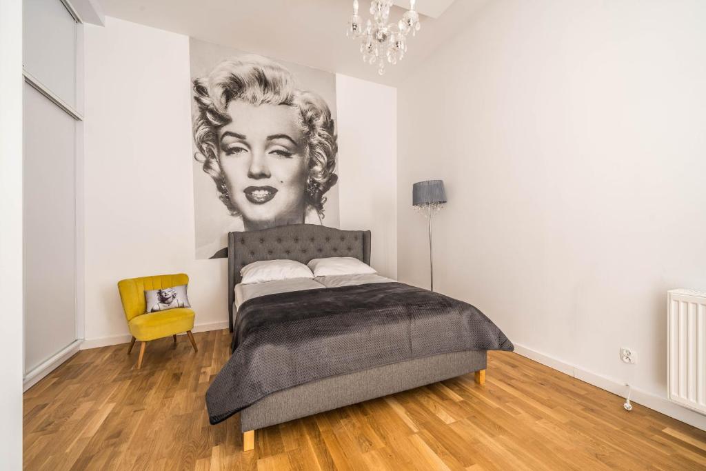 um quarto com uma cama com um retrato de uma mulher em Apartament MARILYN w Kamienicy Wicherkiewiczów em Poznań