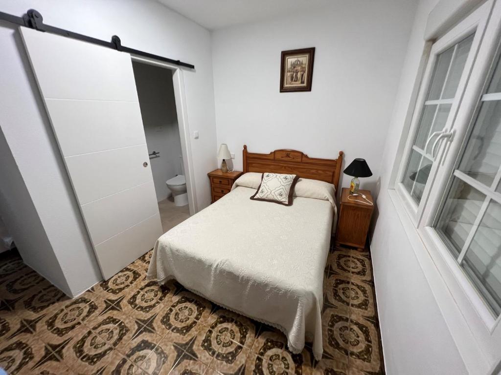 ein kleines Schlafzimmer mit einem Bett und einem Badezimmer in der Unterkunft Luisamar in Muxia