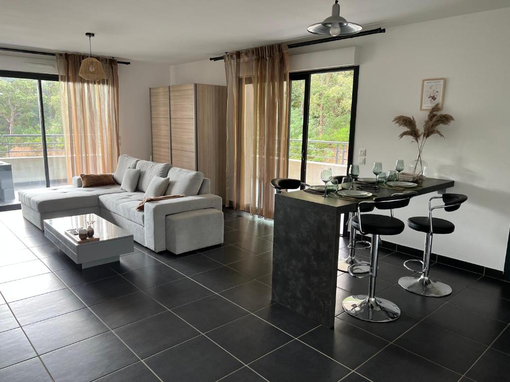 uma sala de estar com um sofá e uma mesa em T2 avec très grande terrasse em Bastia