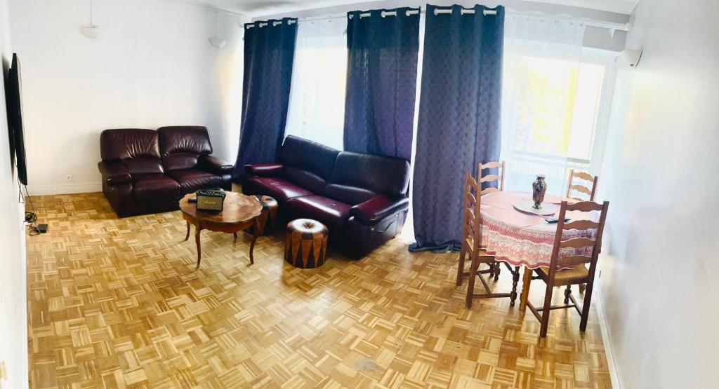 ein Wohnzimmer mit einem Sofa und einem Tisch in der Unterkunft Spacieux et confortable appartement en résidence in Pontoise