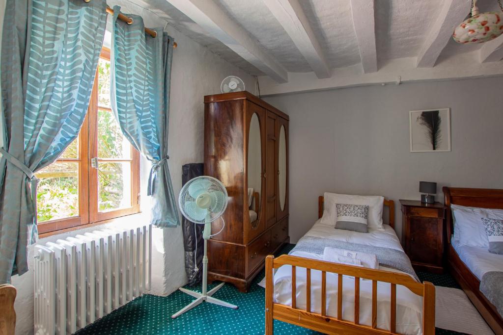 a bedroom with a bed and a fan and a window at ROCHE-LOIRE in Le Thoureil