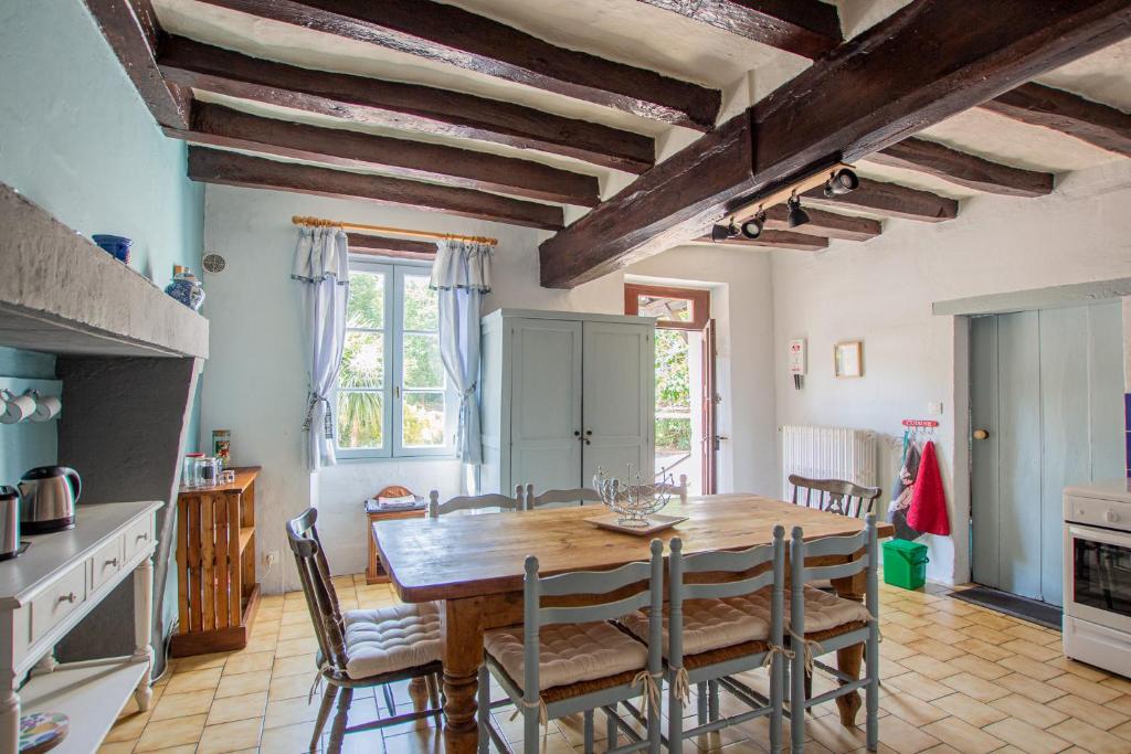 a kitchen and dining room with a wooden table and chairs at ROCHE-LOIRE in Le Thoureil