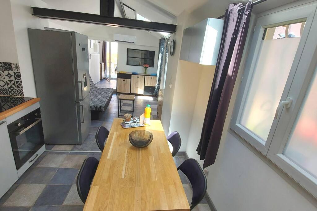 stół i krzesła w pokoju z kuchnią w obiekcie Maisonnette avec terrasse privative w mieście La Ciotat