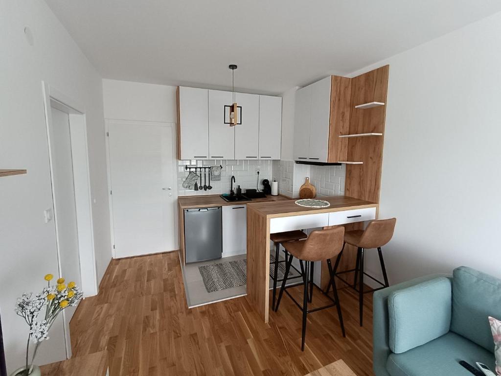 a small kitchen with a counter and a blue couch at Apartment Eight - Pirot in Pirot