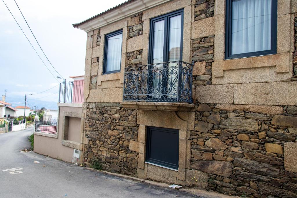 un edificio de piedra con balcón en una calle en Casa De Quintãs, en Vila Real