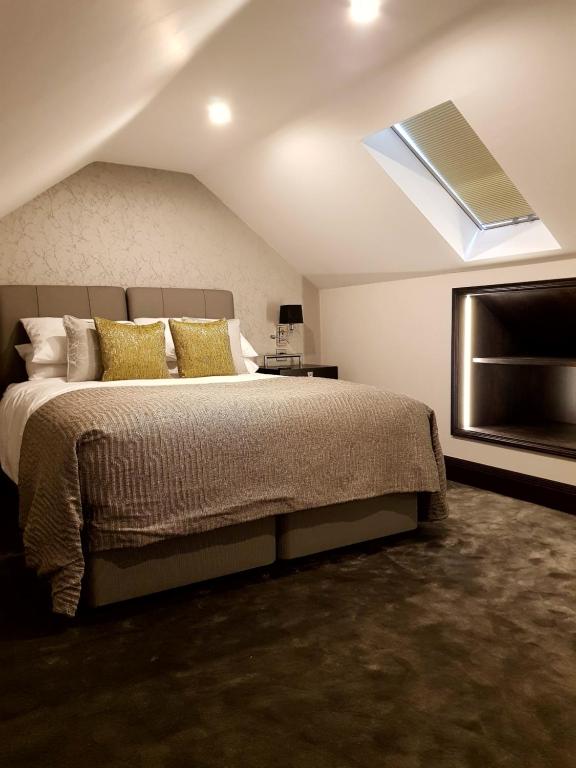 a bedroom with a bed and a skylight at The Queens Head, Parkside Apartment 5 in Burley in Wharfedale