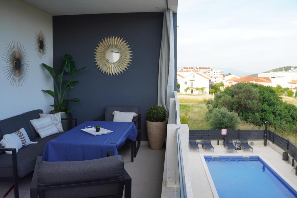 une terrasse avec une table et une piscine dans l'établissement Blue Shell Trogir Apartment, à Trogir