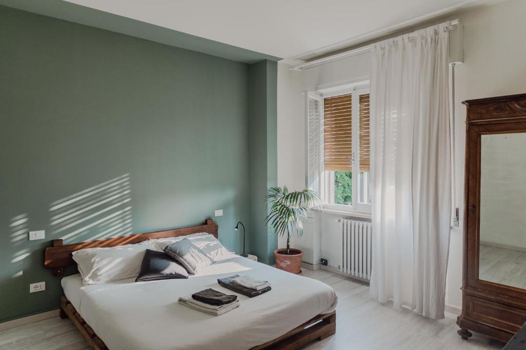 sypialnia z łóżkiem z zielonymi ścianami i oknem w obiekcie Saoō w mieście Garda