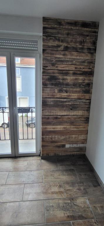 une pièce avec un mur en bois et deux portes coulissantes dans l'établissement F2 Mass & Bo, à Thaon-les-Vosges