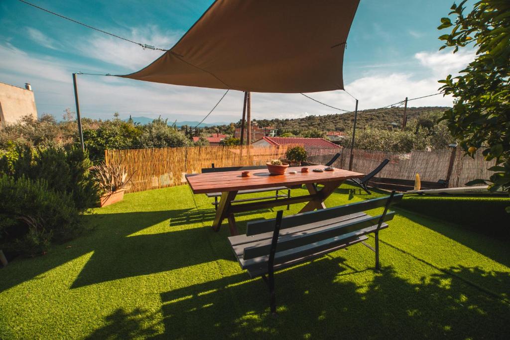 a picnic table and a bench with an umbrella at AKAVA garden house in Volos