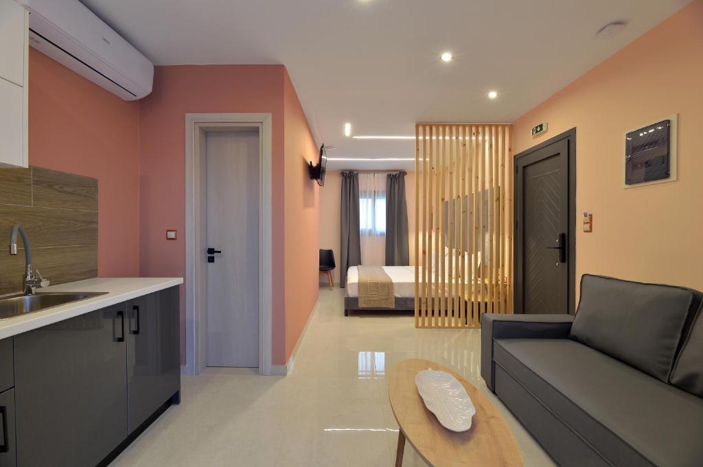 uma cozinha e sala de estar com um sofá e uma cama em Swan Paradise Residences em Loutra Oraias Elenis