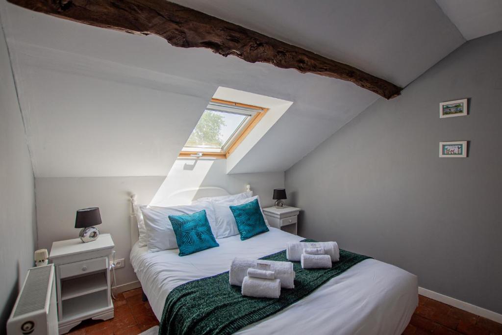 a bedroom with a large white bed with blue pillows at ROCHE-LOIRE in Le Thoureil