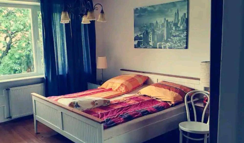 a bed in a bedroom with a window at Przytulny dom z ogrodem i tarasem in Koszalin