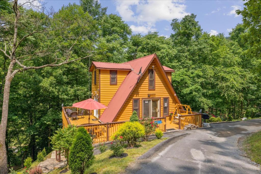 uma casa amarela com um telhado vermelho em Smokey Max Chalet em Sevierville