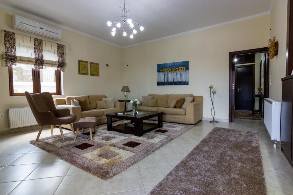 ein Wohnzimmer mit einem Sofa und einem Tisch in der Unterkunft Katerina & Elia's Family House in Leonidi