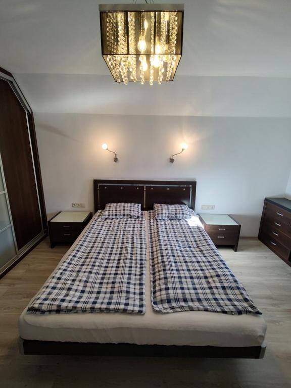 a large bed in a room with a chandelier at Apartament w Sercu Miasta in Elblag