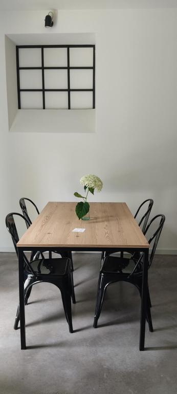 uma mesa de madeira com cadeiras e um vaso com flores em La Crosona em Colà di Lazise