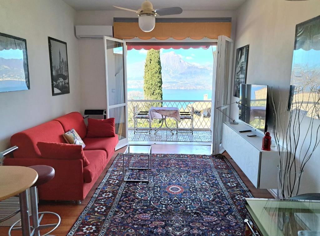 een woonkamer met een rode bank en een balkon bij Garda Panoramic House in Albisano