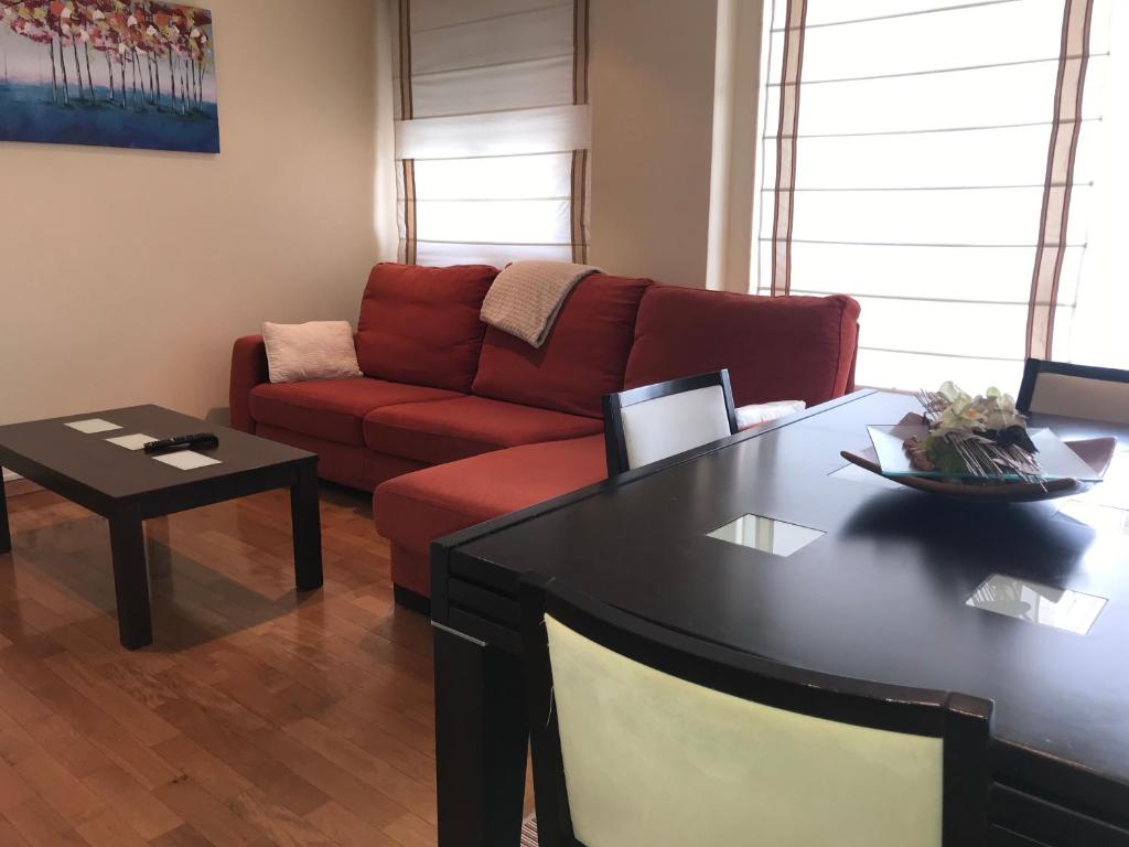 a living room with a red couch and a table at Casa Nano in Sigüeiro