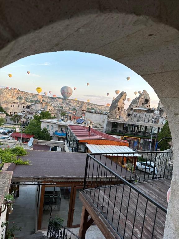 un balcón con vistas a la ciudad y globos de aire caliente en Sunset Cave, en Göreme