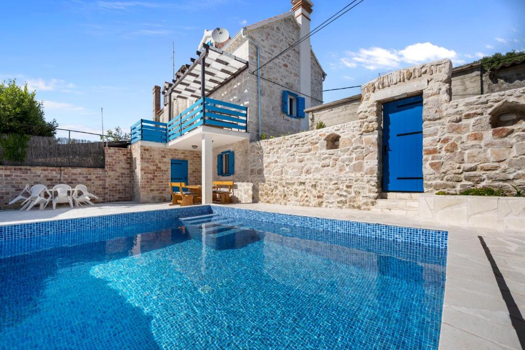 a villa with a swimming pool and a house at House AnaDora with pool - Zlarin in Zlarin