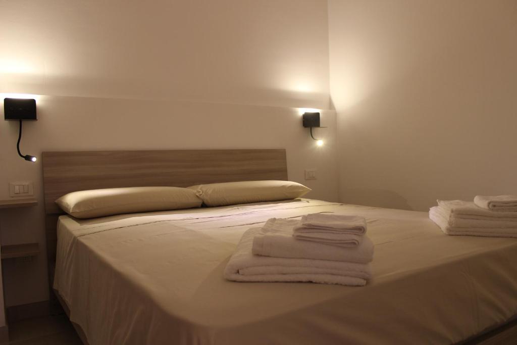 1 dormitorio con 1 cama con toallas en Appartamento Camelia, en Palo del Colle