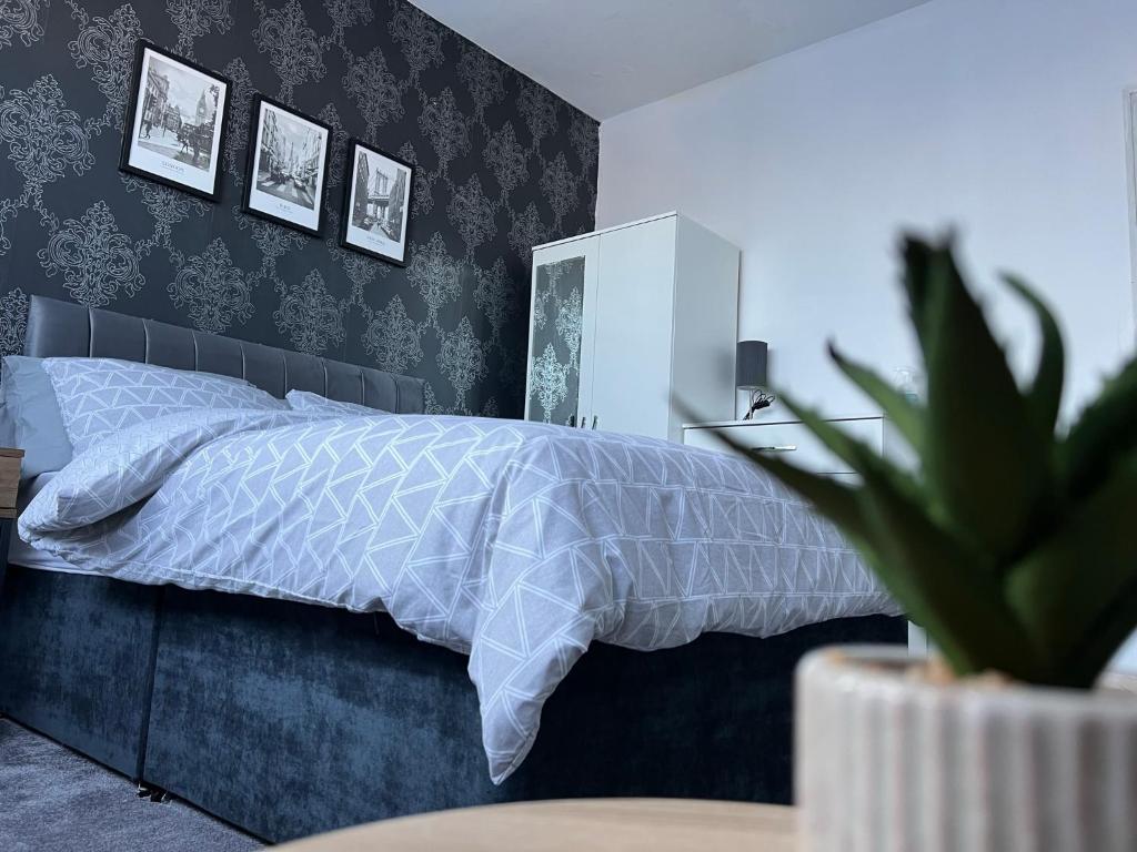 a bedroom with a bed with a white bedspread and a plant at MAISON DE VACANCES in Newport